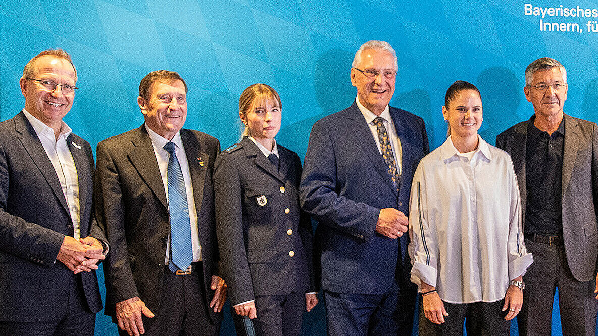Gruppenbild anl. der Pressekonferenz Eure Fans in der Allianz Arena mit Innenminister Joachim Herrmann vor einer blauen Pressewand des StMI.