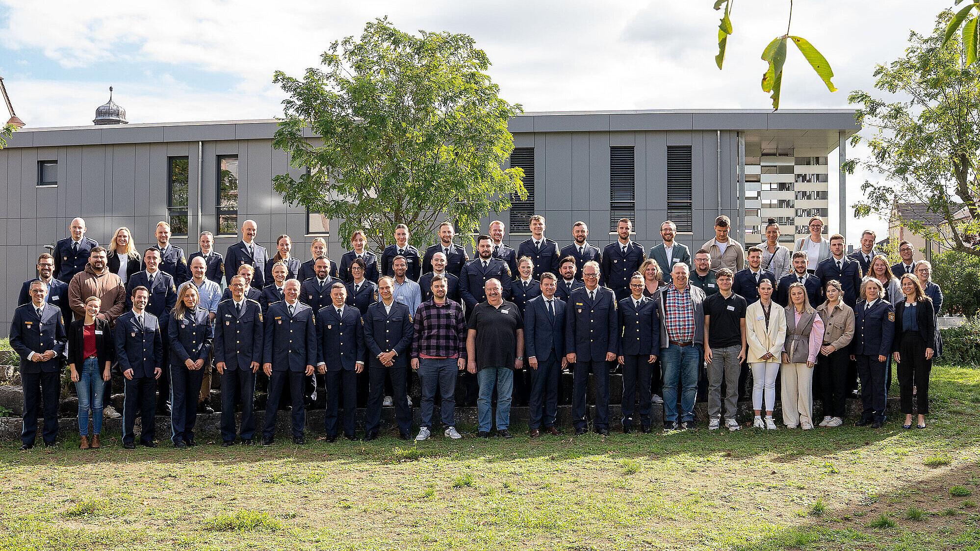 Gruppenfoto im Grünen vor dem Gebäude