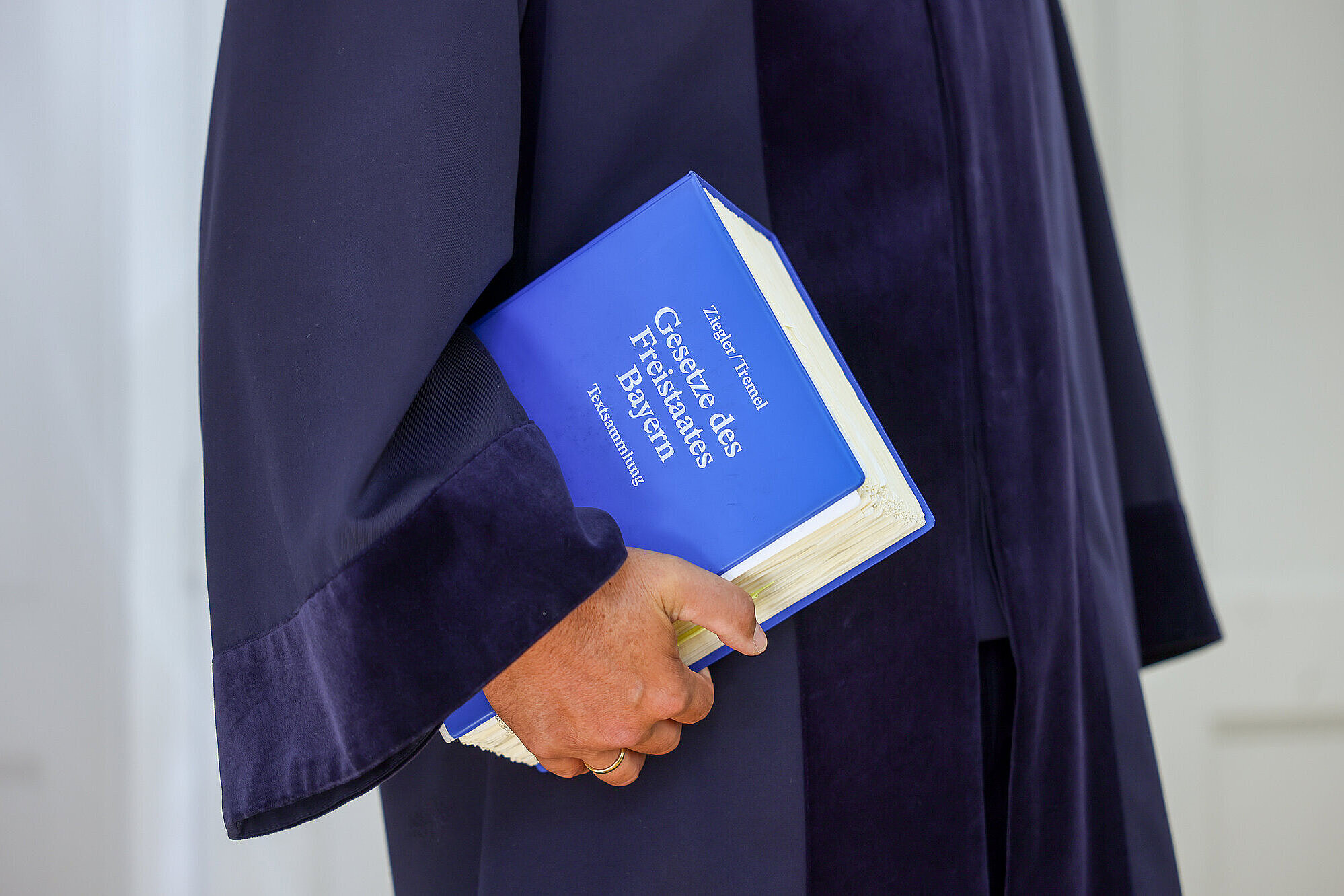 Richter in seiner Robe mit einem Gesetzbuch unter dem Arm