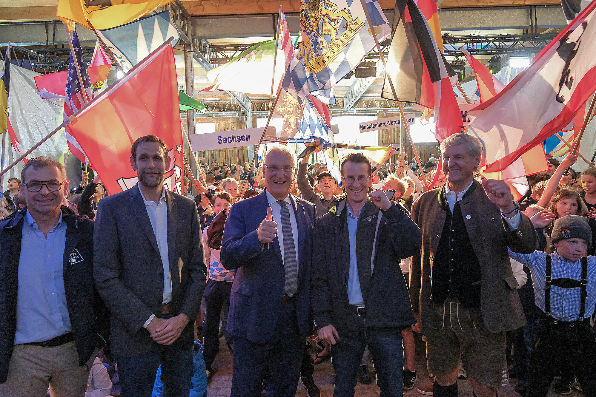 Innenminister Joachim Herrmann, Präsident des Yachtclub Starnberg, Bürgermeister von Starnberg und Landrat Frey vor Kindern mit den Flaggen Ihrer Länder (Bundesländer) als Gruppe lachend in die Kamera.