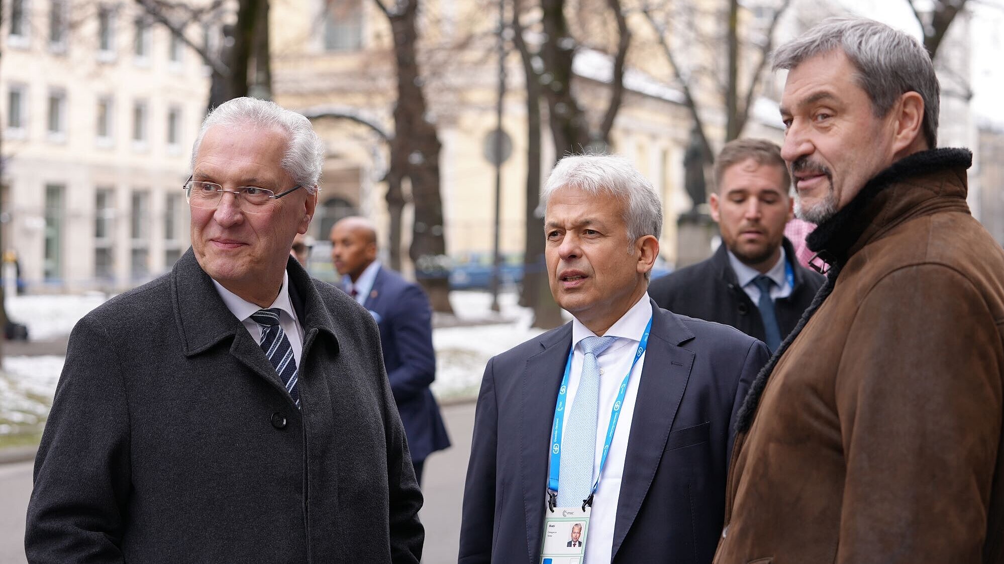 Auf dem Bild sind Innenminister Joachim Herrmann und Ministerpräsident Dr. Markus Söder zu sehen, wie diese am Eingang zur 61. Münchner Sicherheitskonferenz auf die eintreffenden Gäste warten.