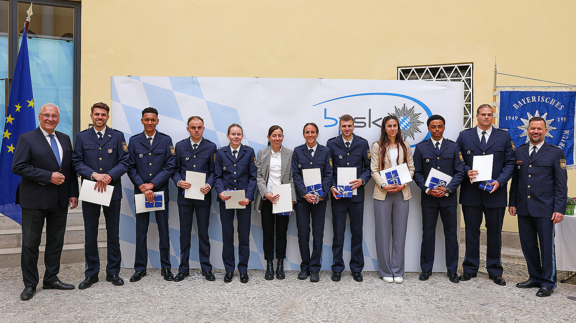 Gruppenbild Polizeispitzensportler und Innenminister Joachim Herrmann im Odeon des Bayerischen Innenministeriums bei der Ehrung, sie halten Ihre Urkunden in den Händen