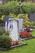 Grabsteine mit vielen bunten Blumen auf einem Friedhof