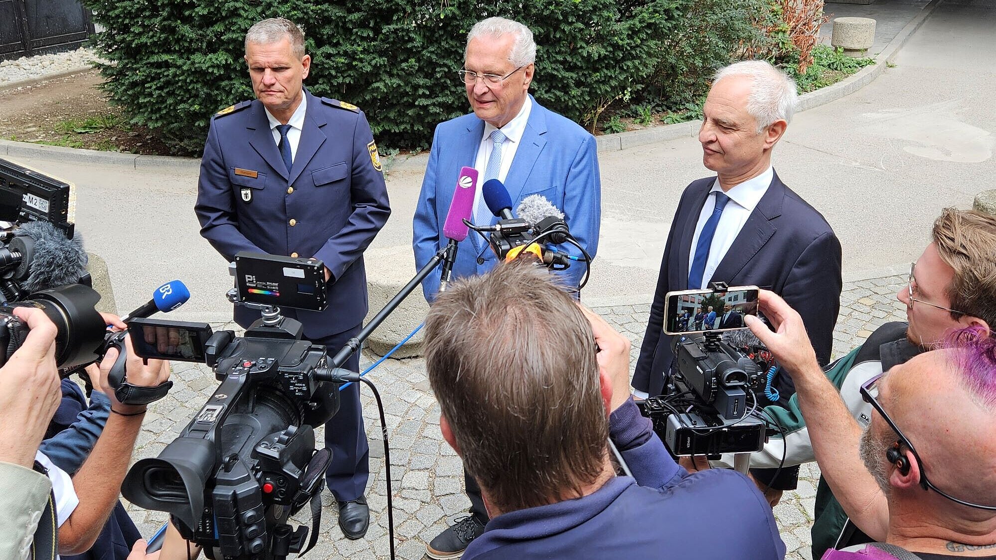 Innenminister Joachim Herrmann mit Regierungspräsident Dr. Konrad Schober und Poizeipräsident Thomas Hampel inmitten von Journalisten und Fernsehkameras 