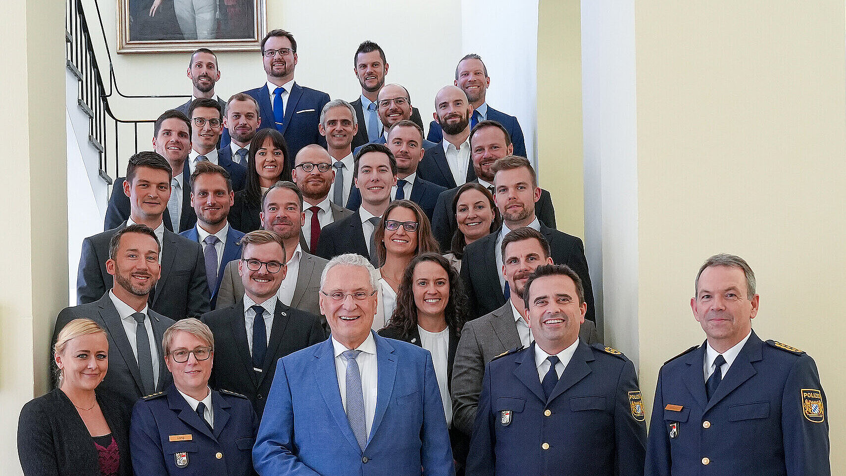 Fototermin im StMI auf der Treppe mit Innenminister Joachim Herrmann und den Absolventen der deutschen Hochschule der Polizei.