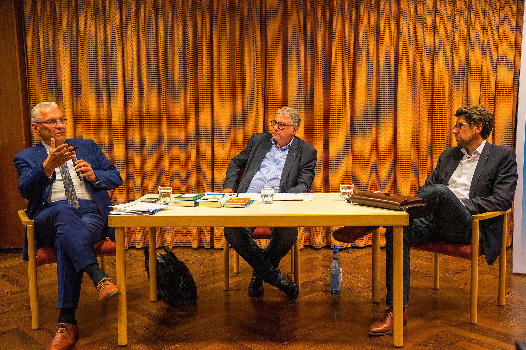 Innenminister Joachim Herrmann im Austausch mit Prof. Dr. Georg Steiner und Dr. Kurt Höller sitzend an einem Tisch 