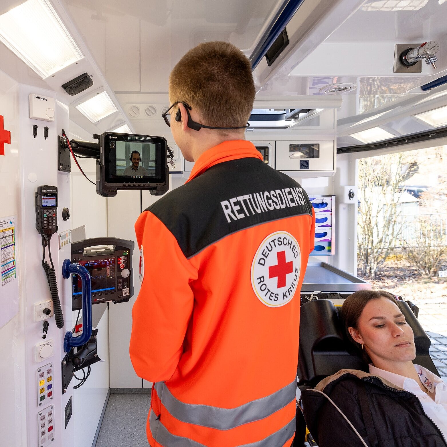 Mann von Rettungsdienst stellt Telenotarztsystem in Rettungswagen vor