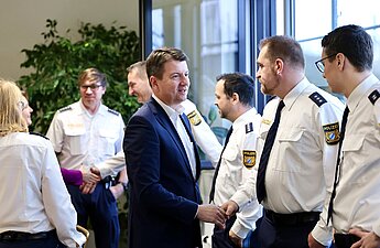 Innenstaatssekretär Sandro Kirchner schüttelt Polizistinnen und Polizisten die Hand.