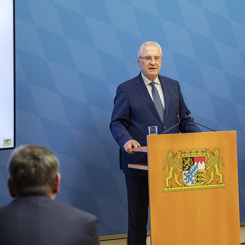 Herrmann und Schwald bei Präsentation hinter Rednerpulten