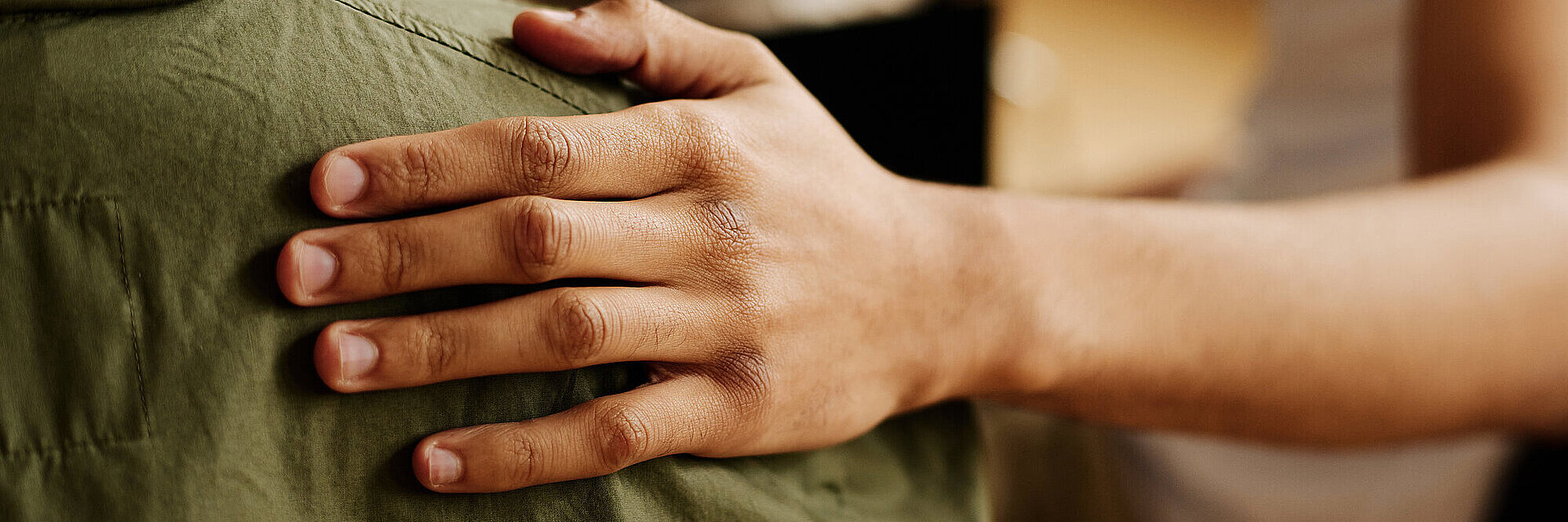 Eine Hand die sich auf eine Schulter legt