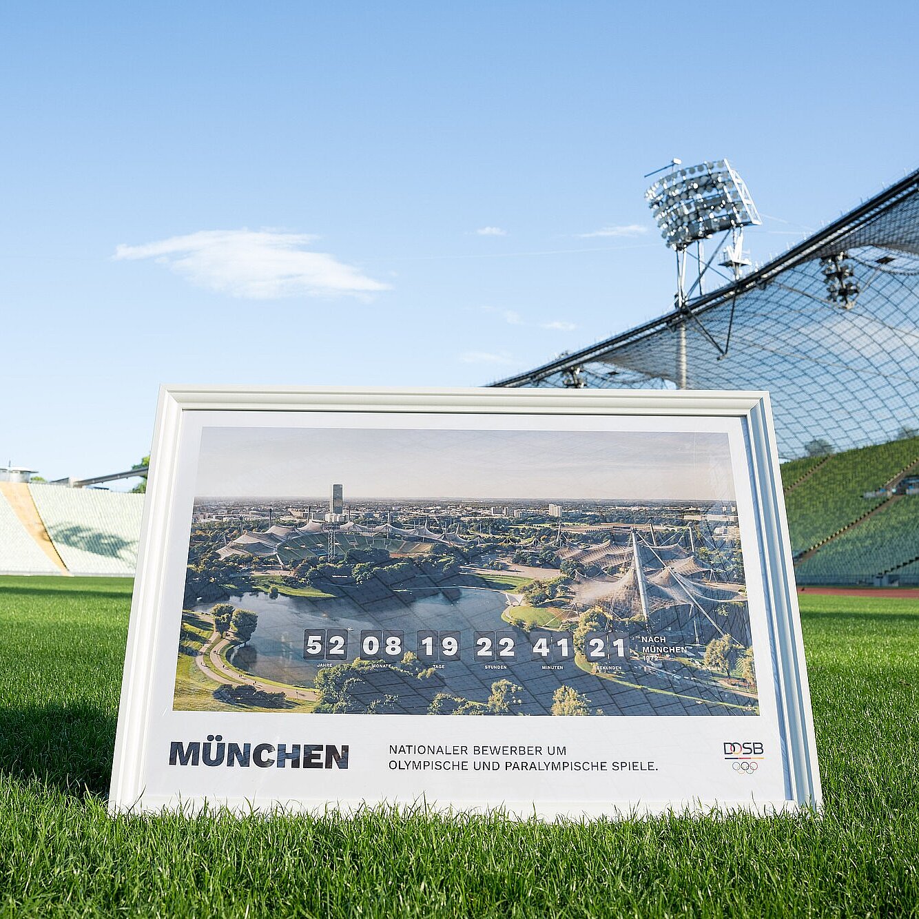 Bild im Rahmen mit Olympiastadion München "Nationaler Bewerber um Olympische und Paralympische Spiele" auf dem Rasen im Olympiastadion München