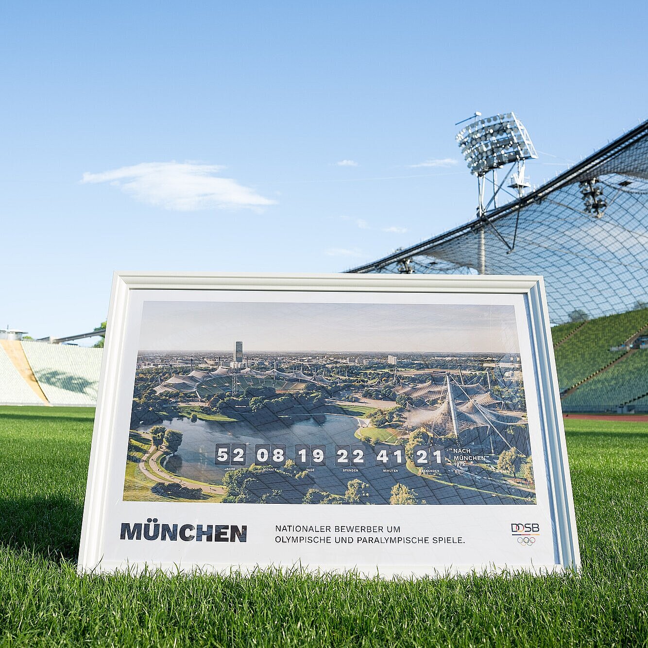 Bild im Rahmen mit Olympiastadion München "Nationaler Bewerber um Olympische und Paralympische Spiele" auf dem Rasen im Olympiastadion München
