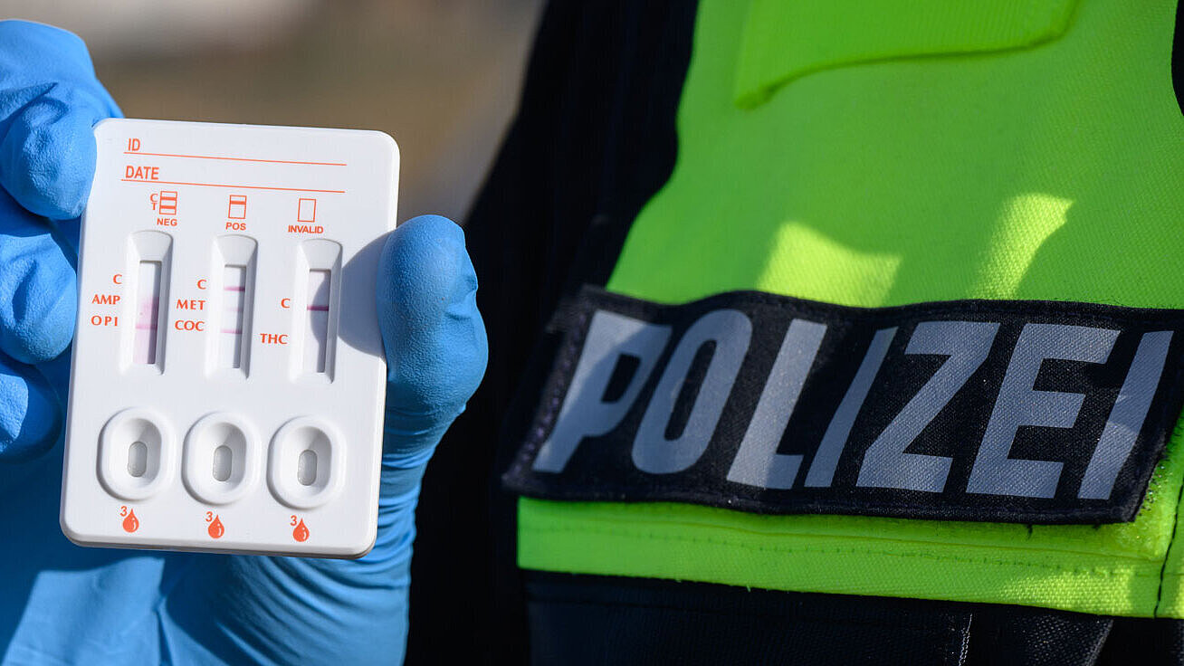 Ein Polizist zeigt einen positiven Drogen-Test auf THC (Cannabis).