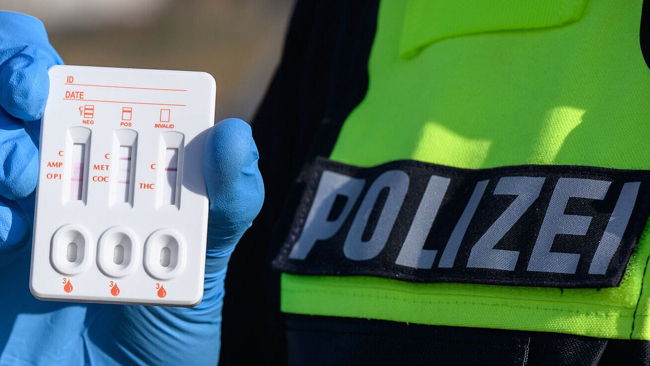 Ein Polizist zeigt einen positiven Drogen-Test auf THC (Cannabis).