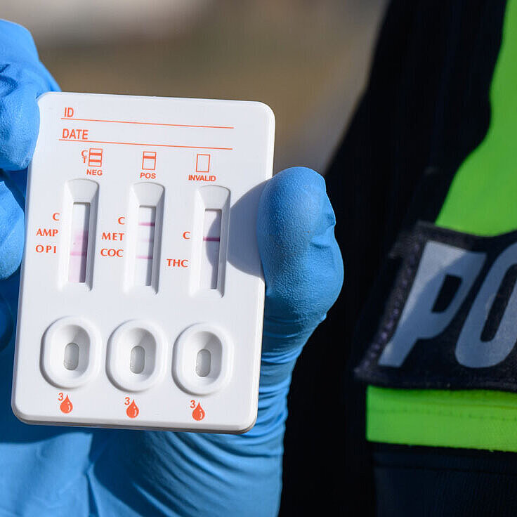 Ein Polizist zeigt einen positiven Drogen-Test auf THC (Cannabis).