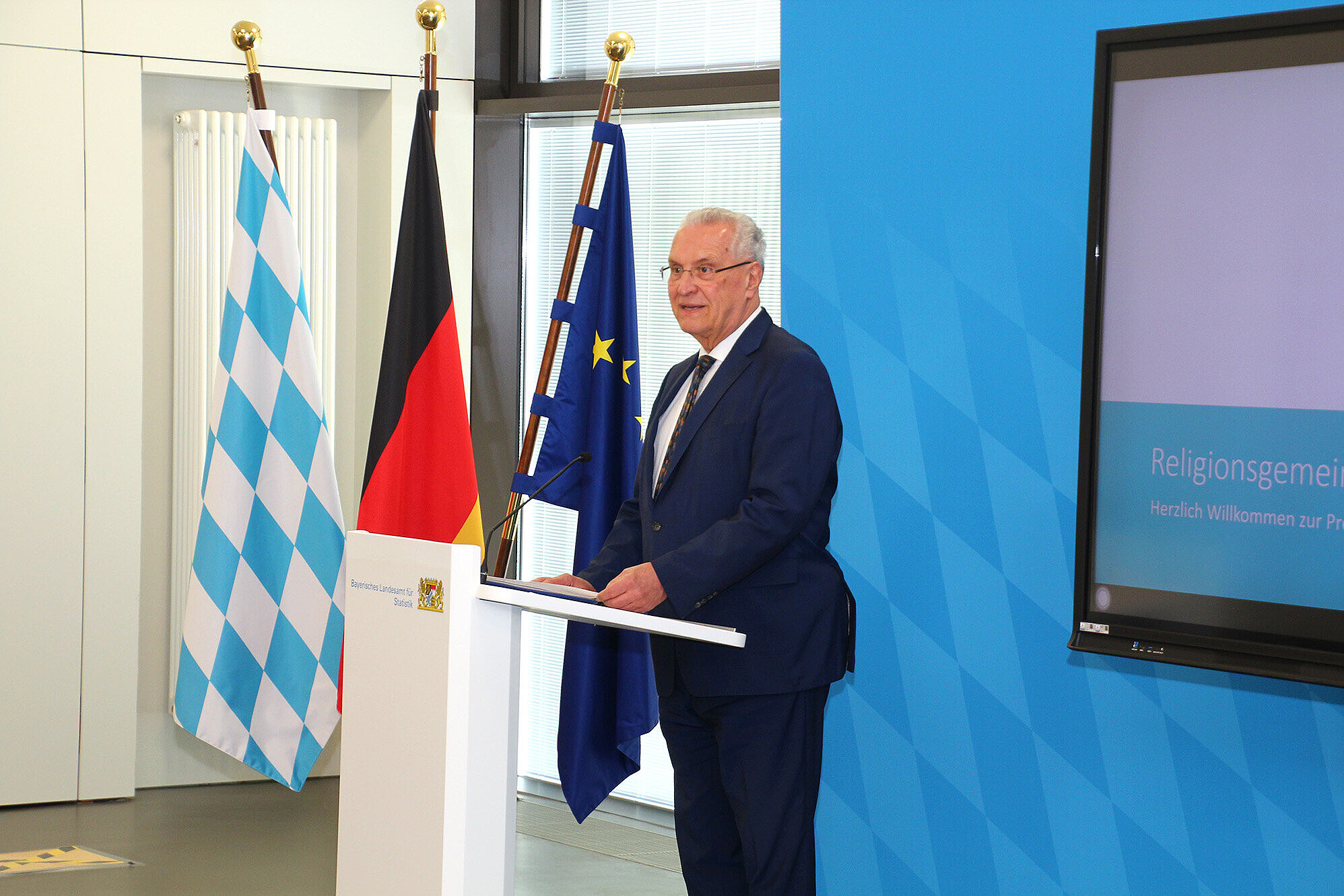 auf dem Bild: Innenminister Joachim Herrmann am Rednerpult bei der Pressekonferenz im Bayerischen Landesamt für Statistik in Fürth