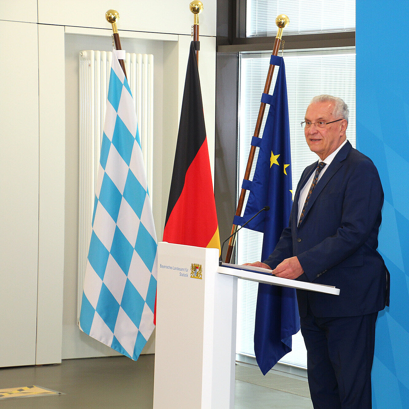 auf dem Bild: Innenminister Joachim Herrmann am Rednerpult bei der Pressekonferenz im Bayerischen Landesamt für Statistik in Fürth