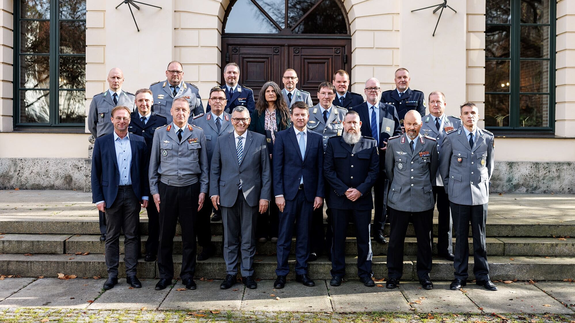 Innenstaatssekretär Sandro Kirchner mit Staatsminister Dr. Florian Herrmann und 14 Geehrten auf den Treppenstufen vor dem Prinz-Carl-Palais.