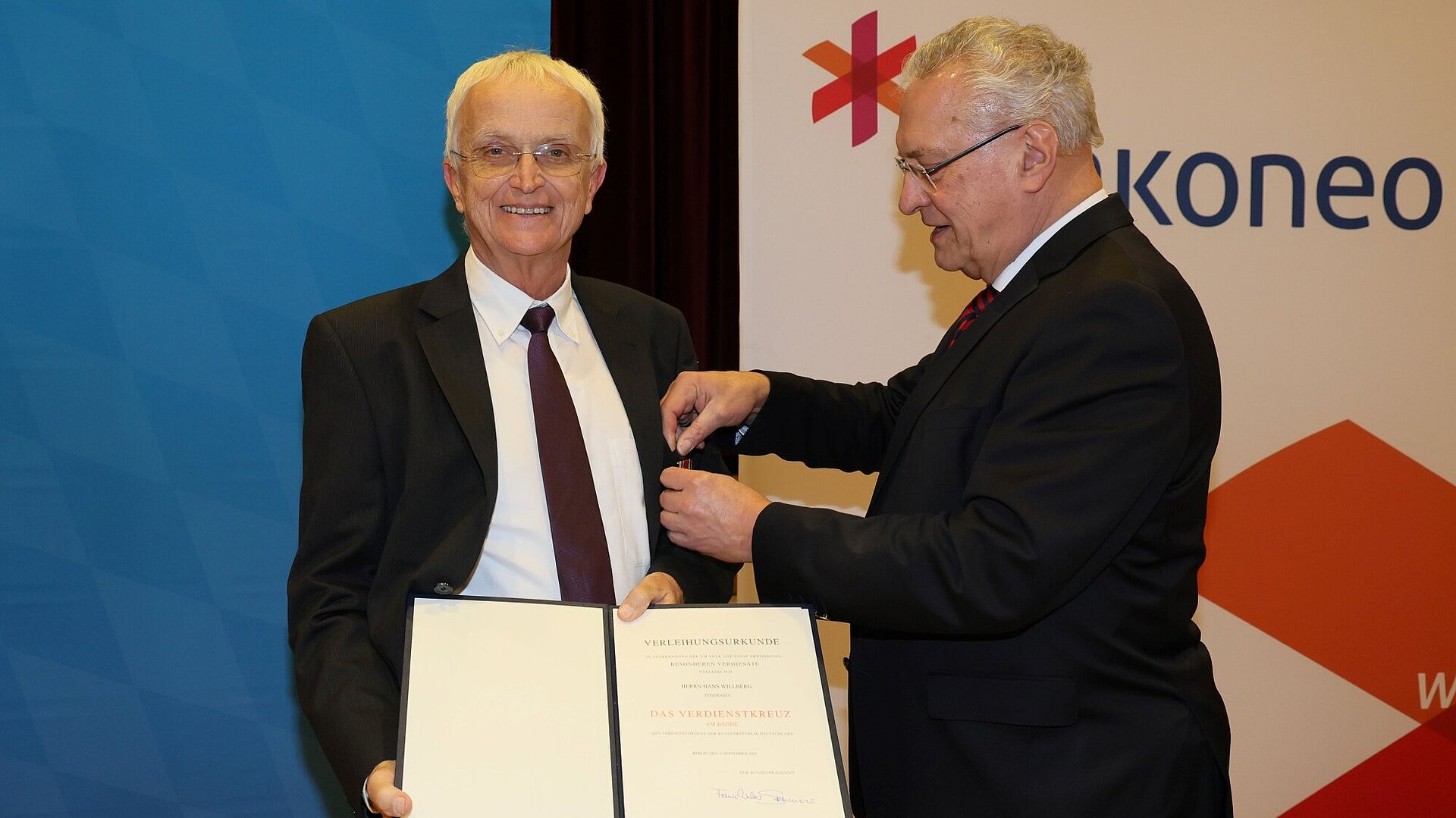 Herrmann steckt Willberg das Verdienstkreuz am Bande an