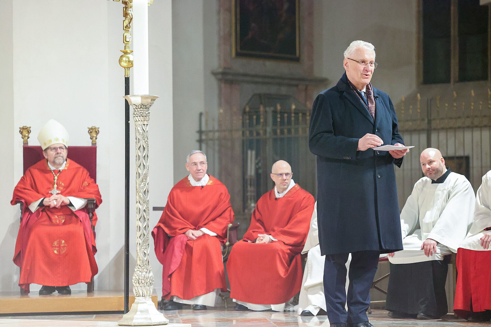 Innenminister Joachim Herrmann vor dem Altar im Liebfrauendom München  mit Blick in den Innenraum bei seinem Grußwort 