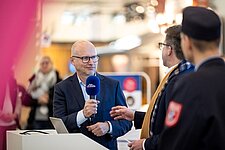 Gunnar Wiegand mit Mikrofon während Bühnentalk