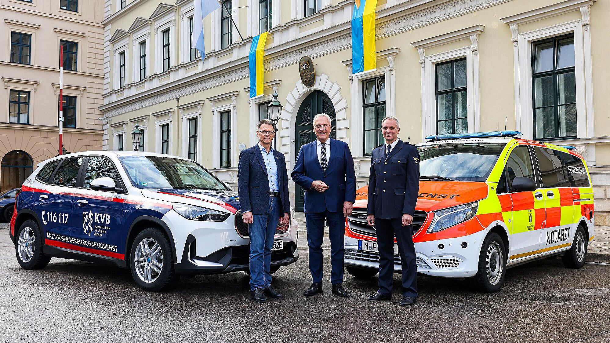 Innenminister Joachim Herrmann mit Dr. Christian Pfeiffer, Vorstandsvorsitzender der KVB und Florentin von Kaufmann, Vorsitzender des Verbandes der Bayerischen Leitstellenbetreiber zwischen Einsatzfahrzeugen des Bereitschaftsdienstes und des Rettungsdiensts