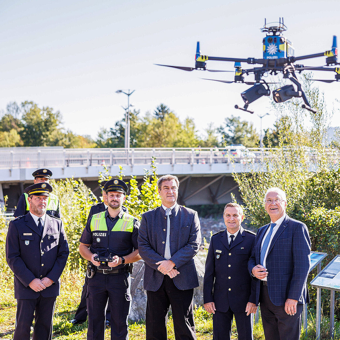 Söder und Herrmann beobachten Polizeidrohne, daneben Grenzpolizisten