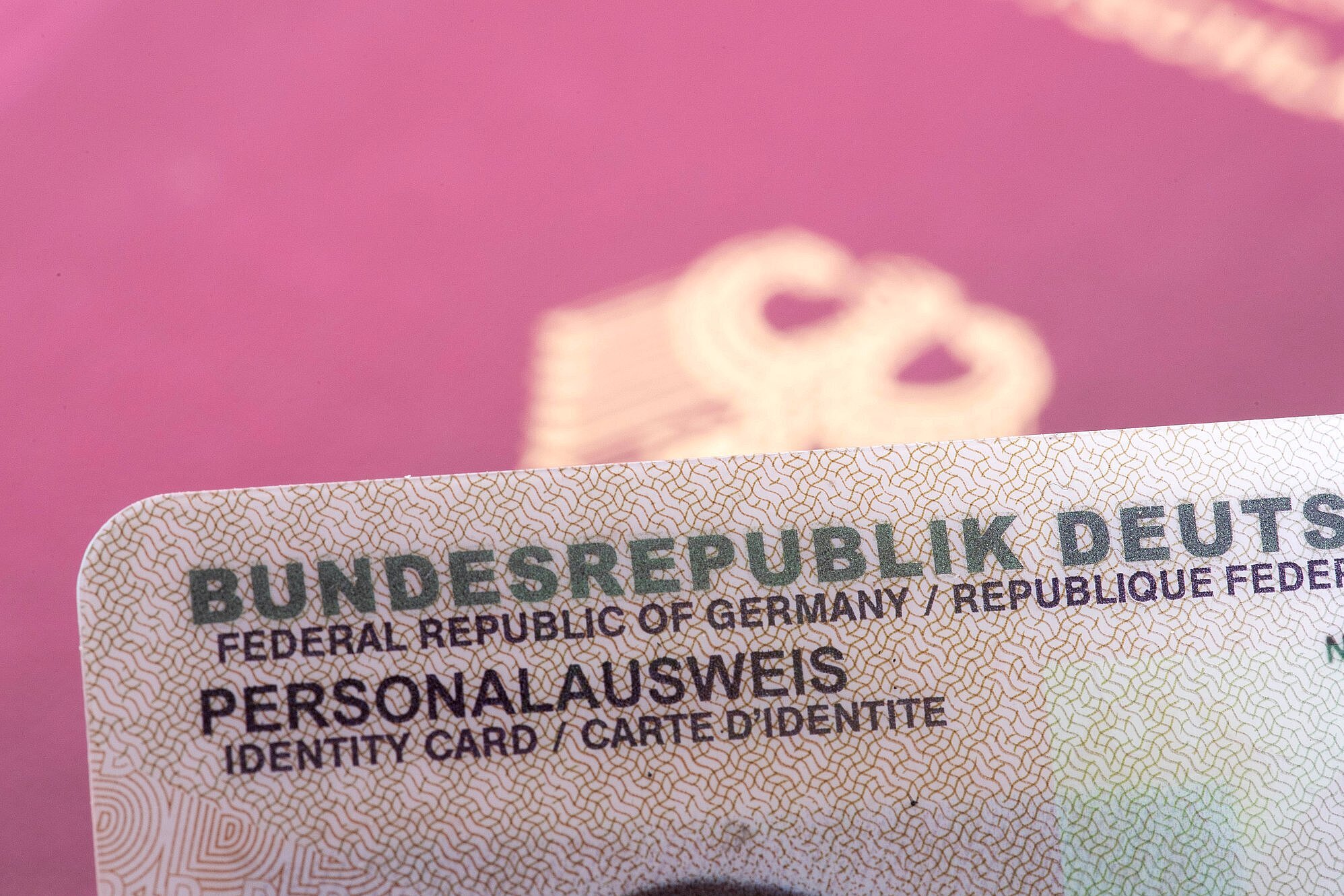 Reisepass teilweise im Hintergrund zu sehen und davor ein Teil des Personalausweises abgebildet