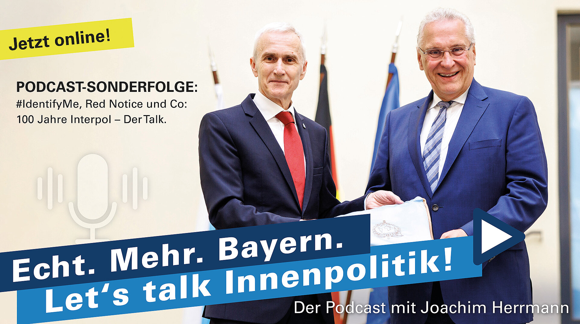 Auf dem Bild sind Innenminister Joachim Herrmann mit dem Interpol-Generalsekretär Prof. Dr. Jürgen Stock zu sehen. Im Hintergrund steht ein Fahnenset