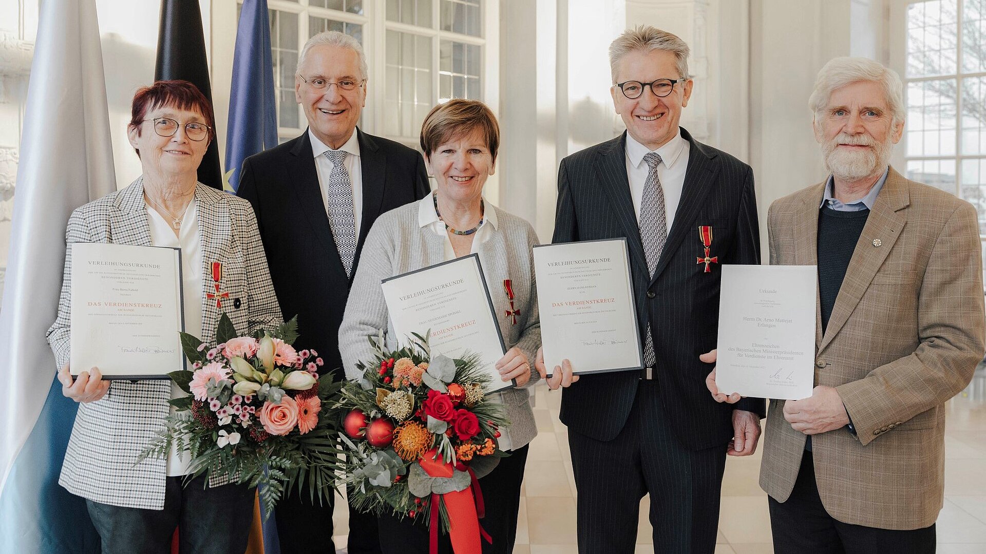 Innenminister Joachim Herrmann mit Berta Faßold, Heidemarie Sponsel, Hans Rebhan und Dr. Arno Mattejat mit Urkunden, Verdienstkreuzen, Ehrenzeichen und Blumensträußen