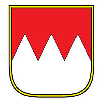 Das Landessymbol Franken, der rot-weiße Rechen ist mit drei aus dem Weiß aufsteigenden Spitzen geteilt.