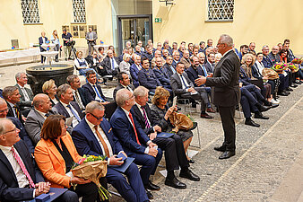Gäste und Teilnehmer der Verleihung Stern der Sicherheit sitzend im Odeon des Bayerischen Innenministeriums, in der Mitte steht Innenminister Joachim Herrmann
