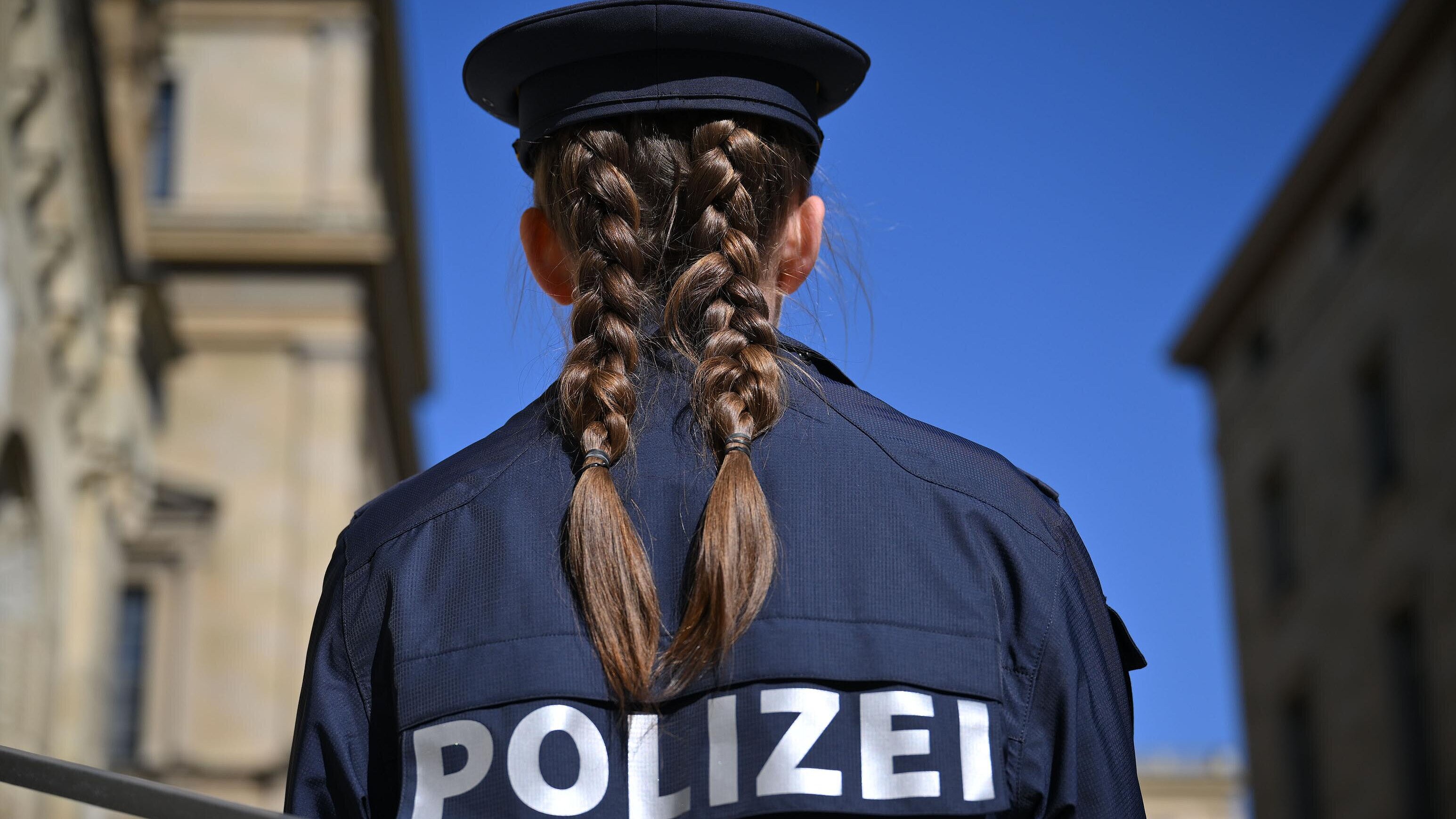 Polizistin von hinten, im  Hintergrund Gebäude in München