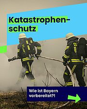 Das Bild zeigt zwei Feuerwehrleute in voller Schutzkleidung und Atemschutz, die einen Löschschlauch halten und Rauch in einem offenen Gelände bekämpfen. Im oberen Bereich des Bildes steht in großen, fettgedruckten Buchstaben „Katastrophenschutz“ auf einem hellblauen und grünen Hintergrund. Unten rechts im Bild ist auf dunkelblauem Hintergrund die Frage „Wie ist Bayern vorbereitet?!“ mit einem grünen Pfeil nach rechts zu lesen. Das Bild vermittelt das Thema Katastrophenschutz und die Vorbereitung Bayerns auf Notfälle.
