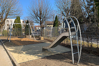Spielplatz mit Rutsche und Schaukel auf dem Gelände einer Ankereinrichtung