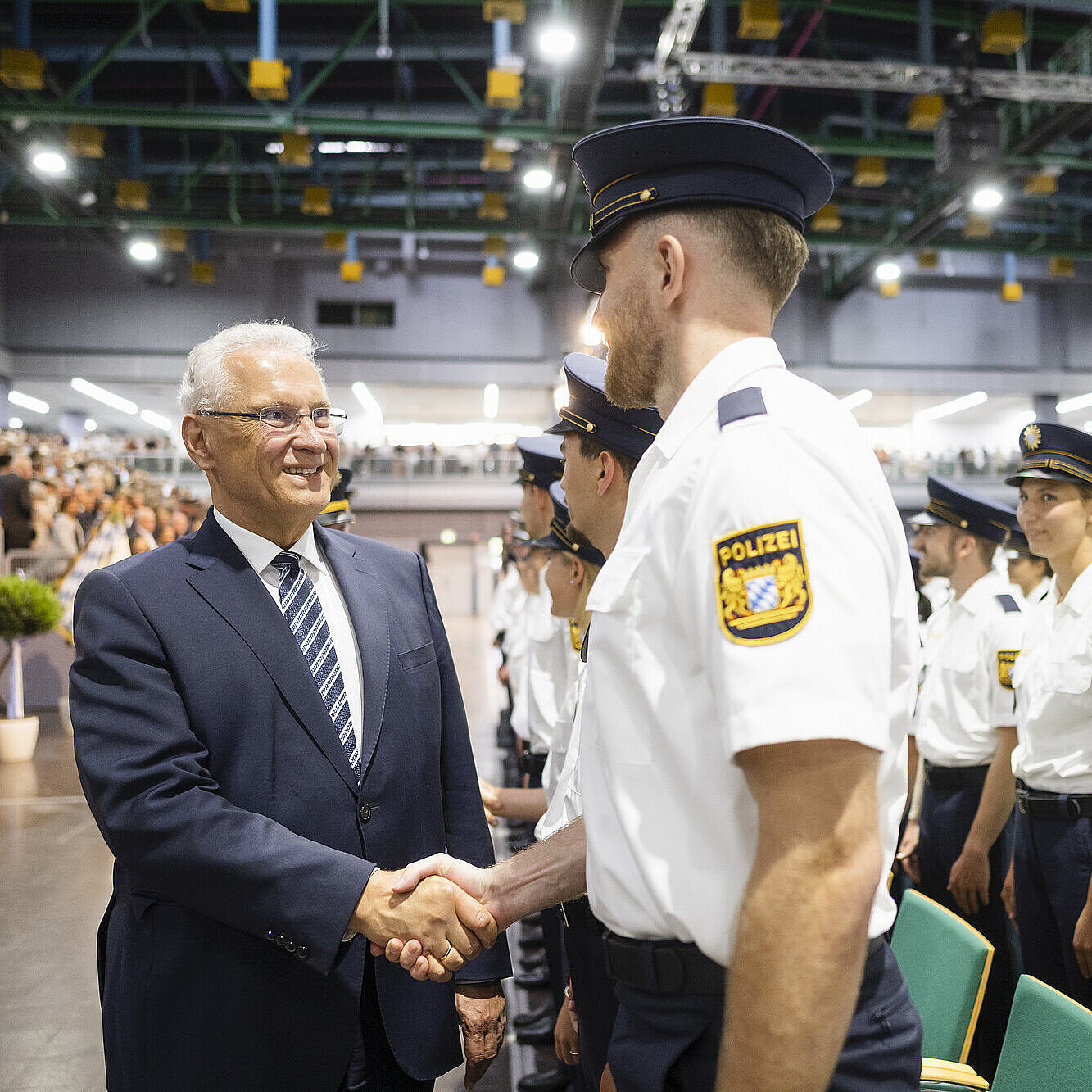 Herrmann schüttelt Polizist die Hand, rechts viele weitere Polizisten
