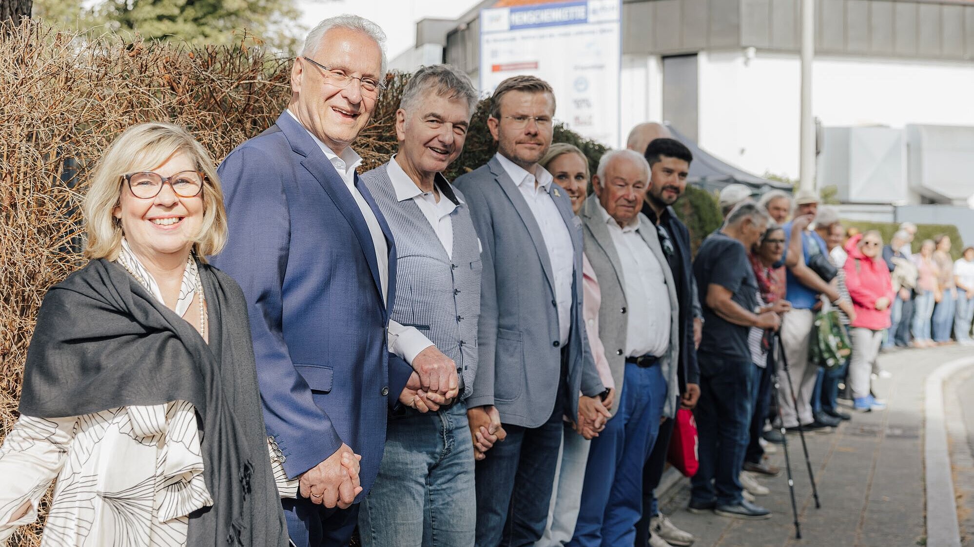 Auf dem Bild ist Innenminister Joachim Herrmann mit weiteren Teilnehmerinnen und Teilnehmern der Menschenkette zu sehen