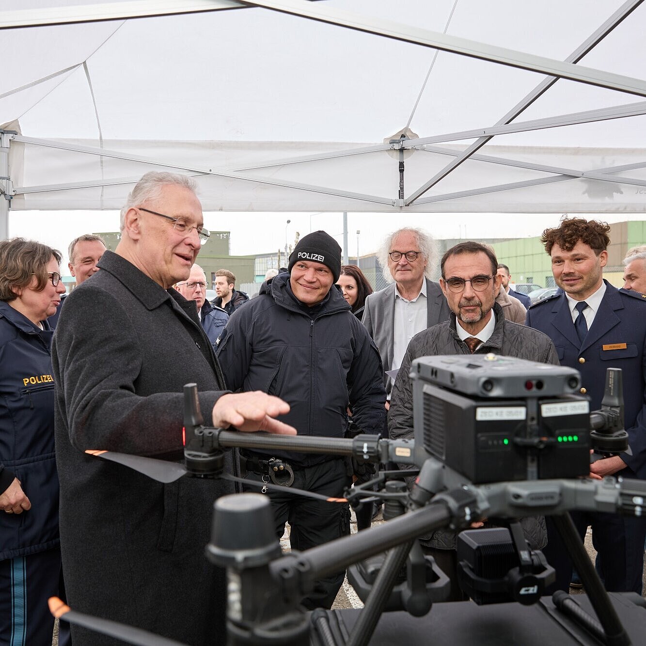 Innenminister Herrmann spricht zu Publikum, im Vordergrund eine Drohne