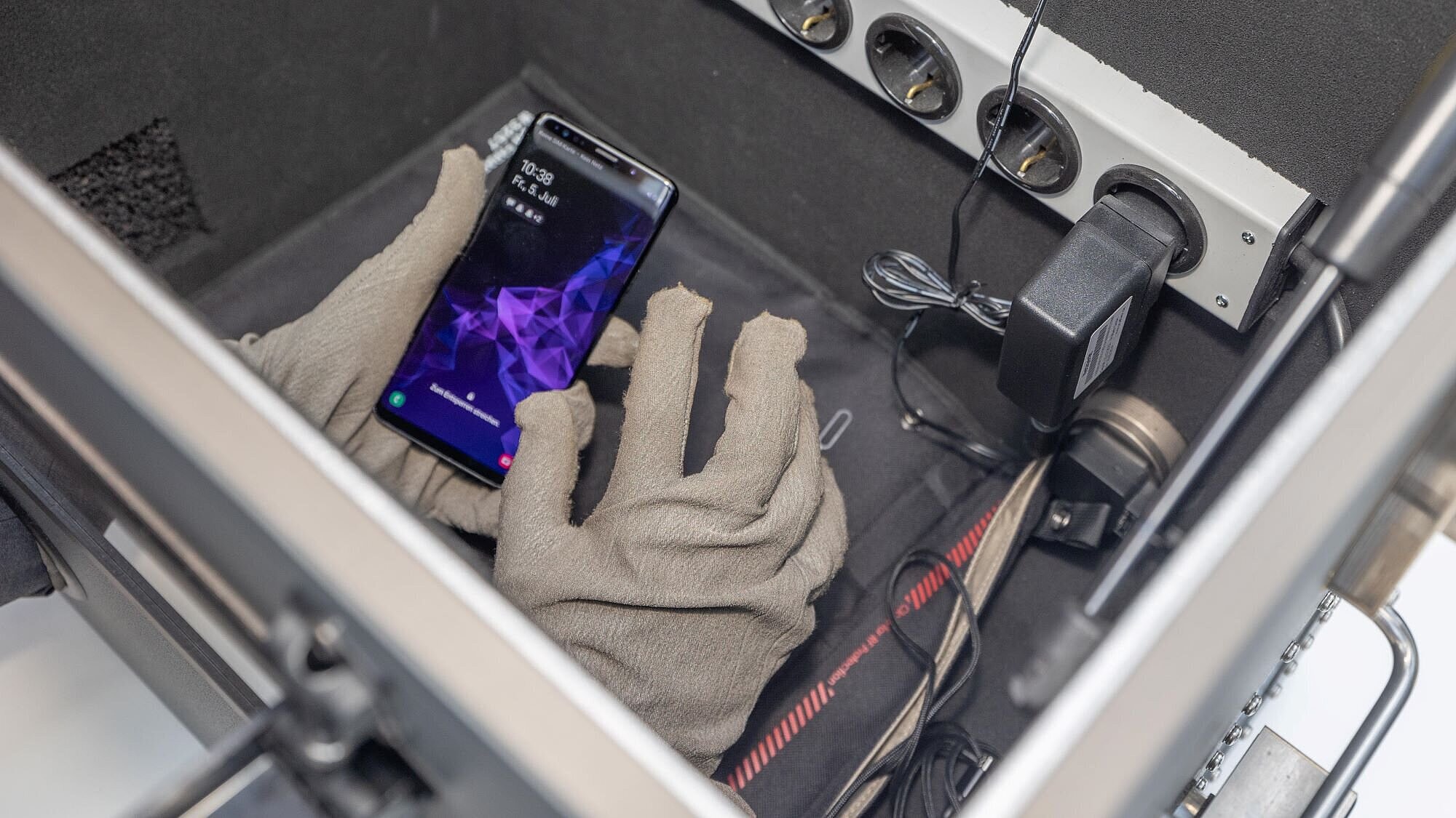 Smartphone wird in einer technischen Box gehalten