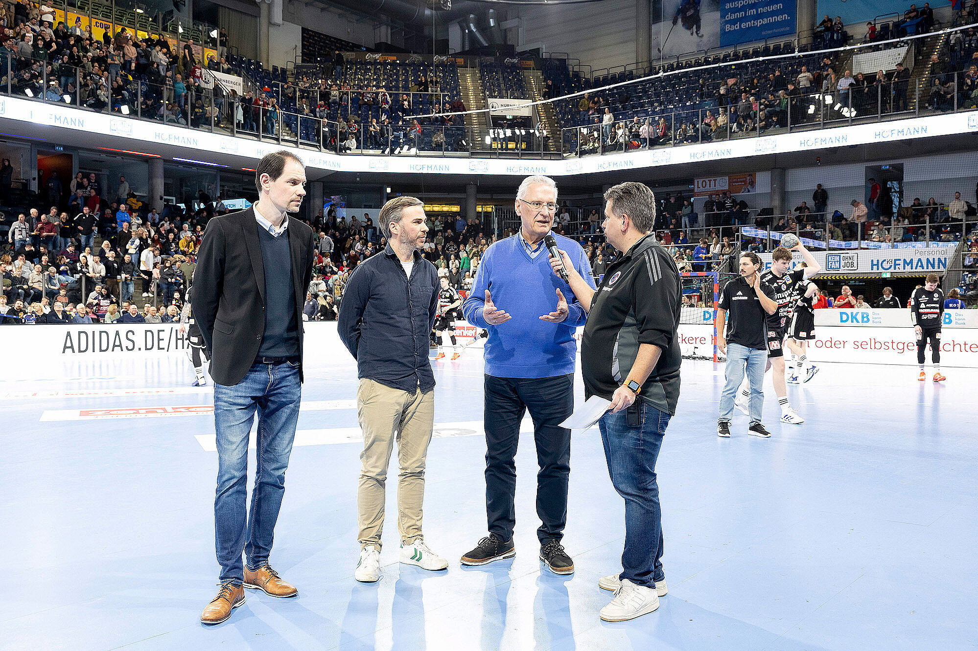 im Bild: auf der Eisfläche Minister Herrmann und Vertreter des HC Erlangen und der Moderator mit einem Aufruf ins Publikum
