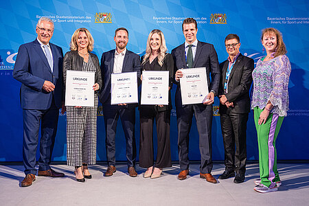 Innenminister Joachim Herrmann mit der Staatssekretärin für Sport und Ehrenamt des Landes Nordrhein-Westfalen, sowie den ausgezeichneten Firmen