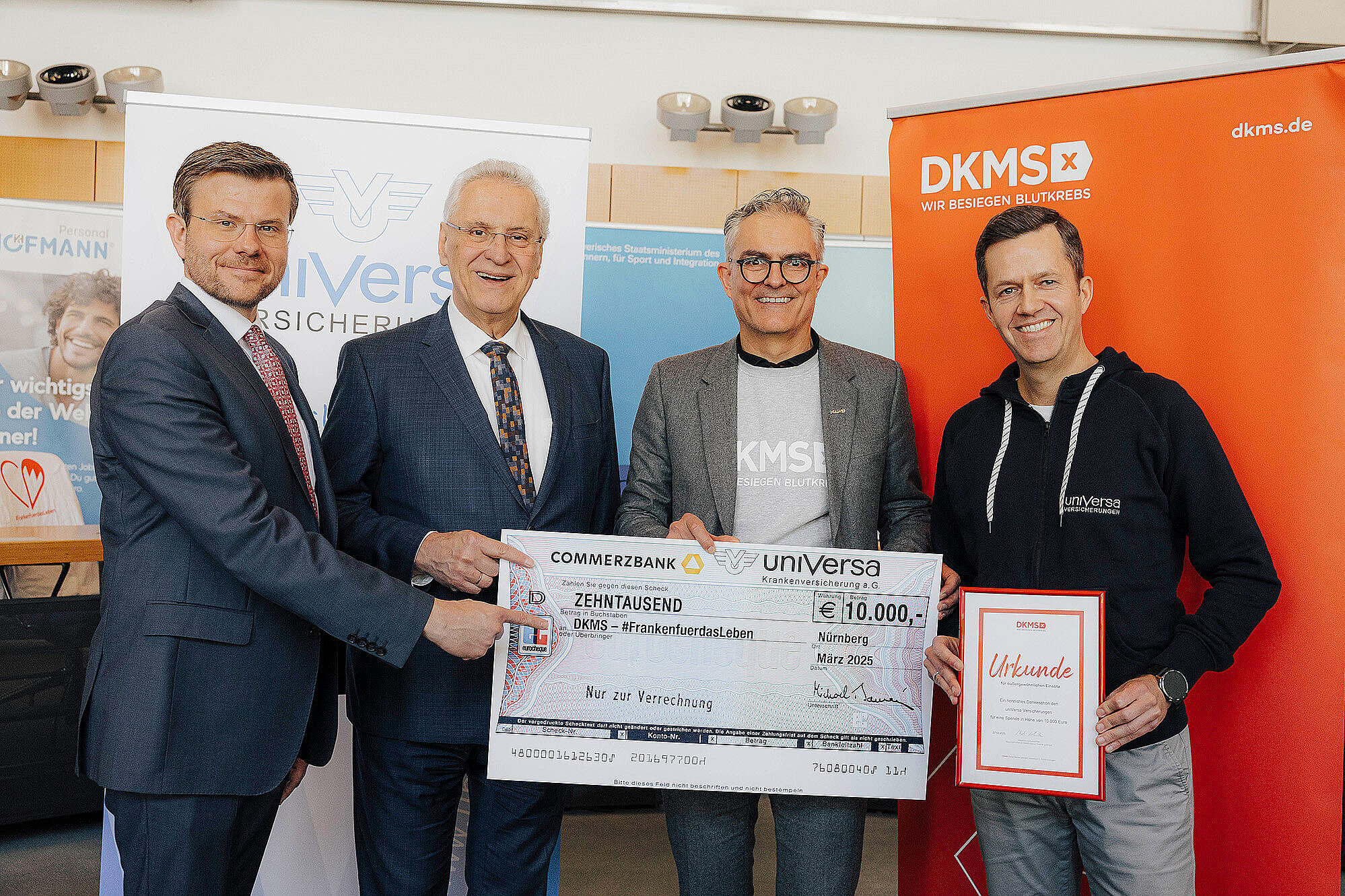 auf dem Bild von links nach rechts: Nürnbergs OB König, Innenminister Herrmann, Unterstützter von Sparkasse mit einem Scheck über 10.00 Euro in der Hand