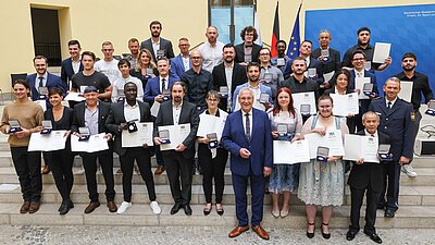Auf dem Bild sind Herr Staatsminister Joachim Herrmann sowie Landespolizeipräsident Michael Schwald mit den mit der "Courage-Medaille" ausgezeichneten Personen zu sehen.