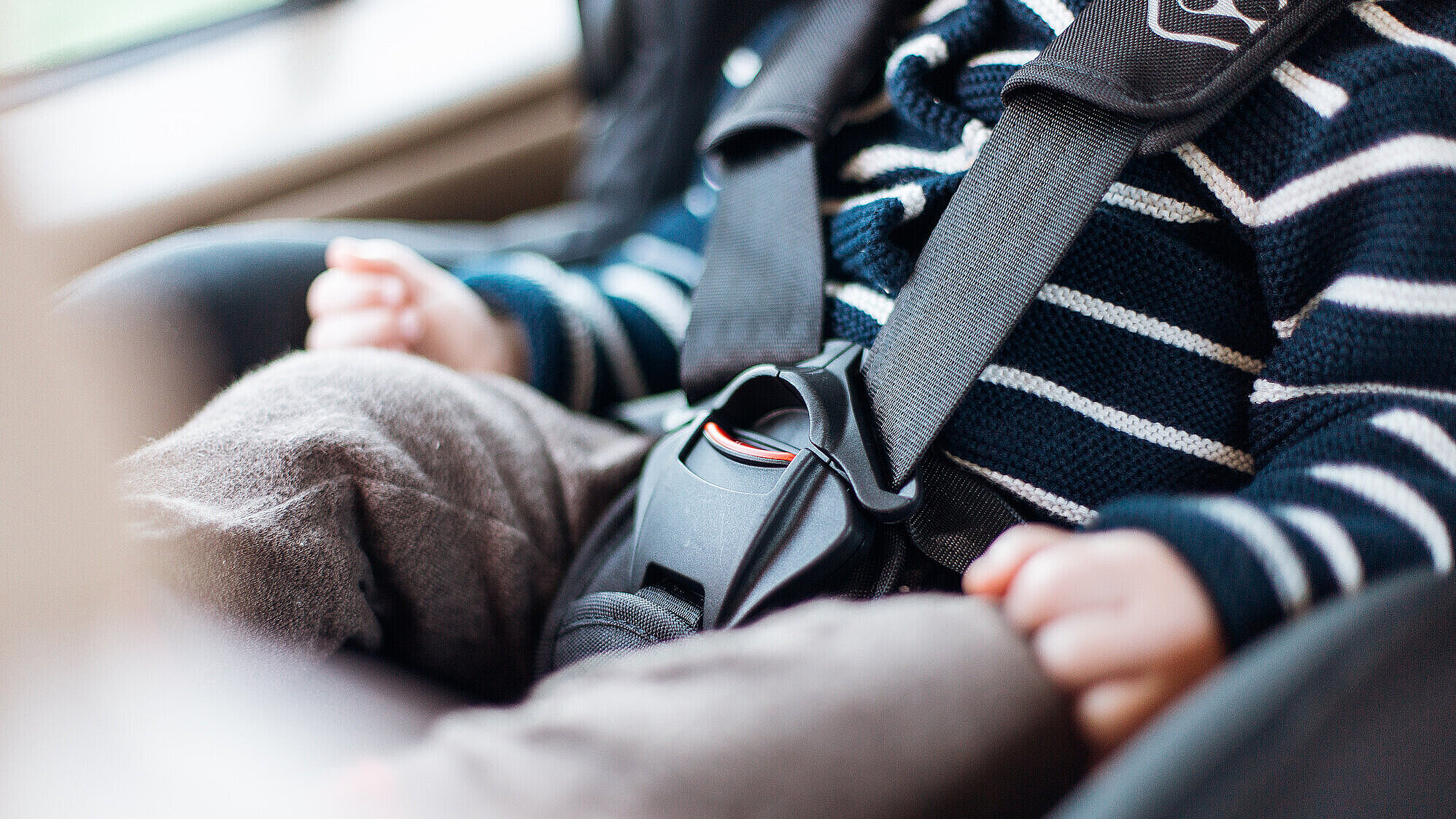 Detailfoto von Kind mit Anschnallgurt in Auto