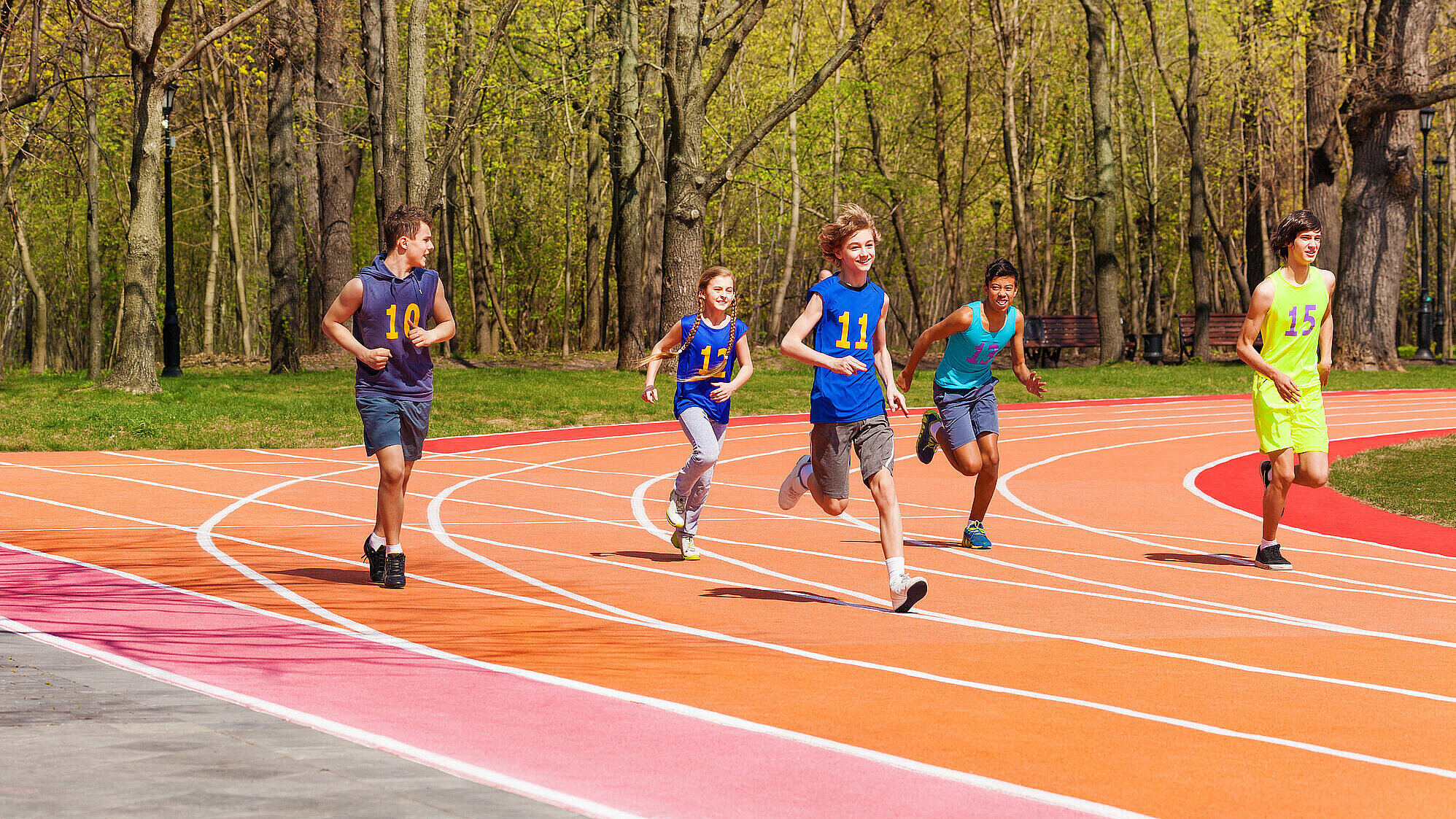 Jugendliche laufen auf Tartanbahn