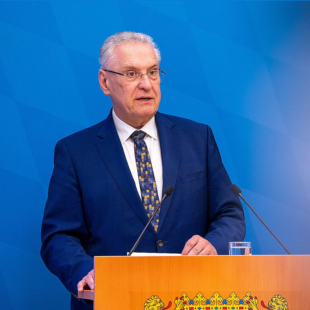 Innenminister Joachim Herrmann ernst blickend am Rednerpult