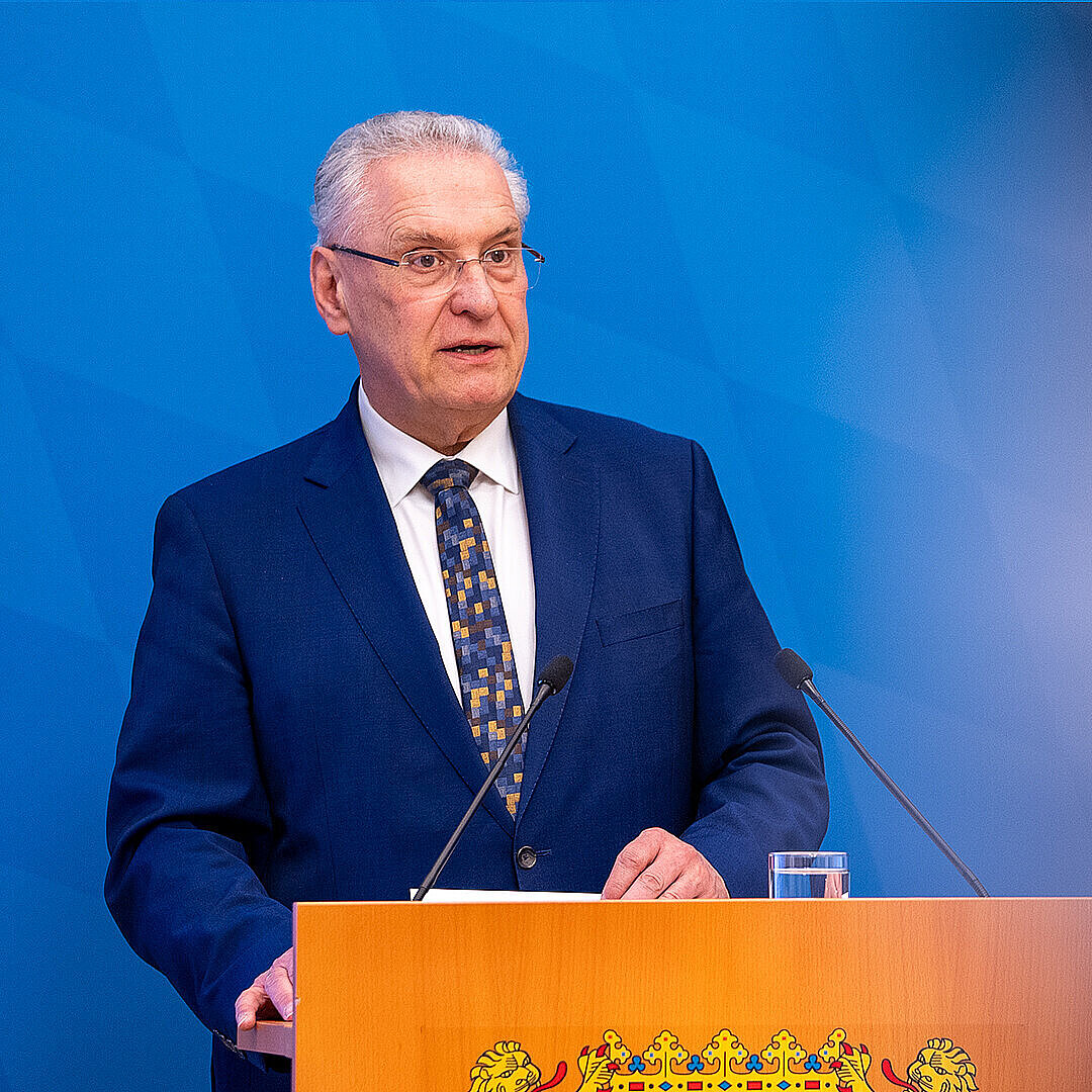 Innenminister Joachim Herrmann ernst blickend am Rednerpult