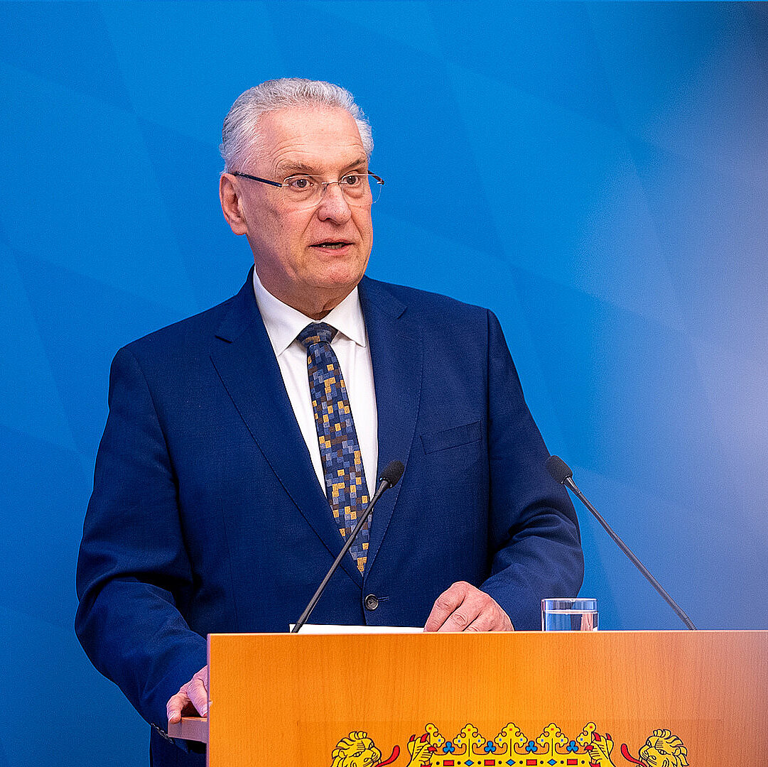Innenminister Joachim Herrmann ernst blickend am Rednerpult