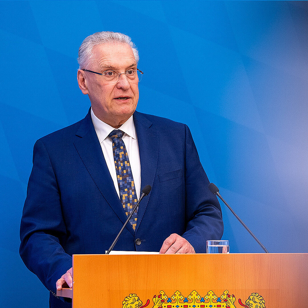 Innenminister Joachim Herrmann ernst blickend am Rednerpult