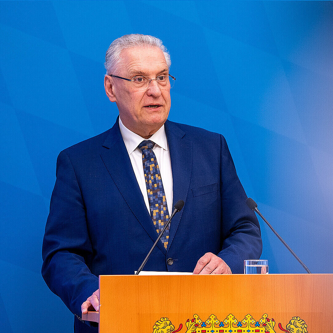 Innenminister Joachim Herrmann ernst blickend am Rednerpult